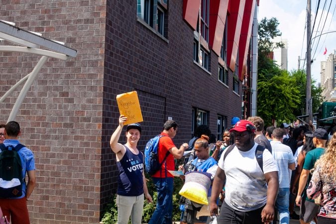 Hayden Smith, an organizer with NextGen, encourages Temple University students to sign up to vote. (Brad Larrison for WHYY)