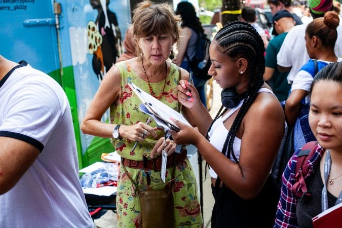 Kimberly Mehler, a volunteer with NextGen, helped students at Temple University register to vote Monday. (Brad Larrison for WHYY)