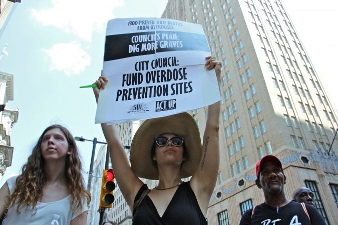 Protesters from ACT UP and Sol Collective gather outside City Hall to demand funding for overdose prevention sites in Philadelphia. (Emma Lee/WHYY)