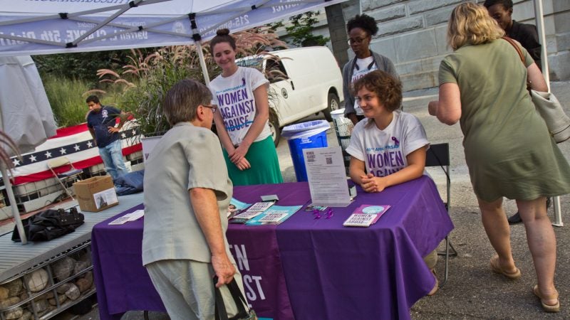 Women Against Abuse hand out resources at a candlelight vigil for Linda Rios, who served as director of human resources for Philadelphia City Council. (Kimberly Paynter/WHYY)