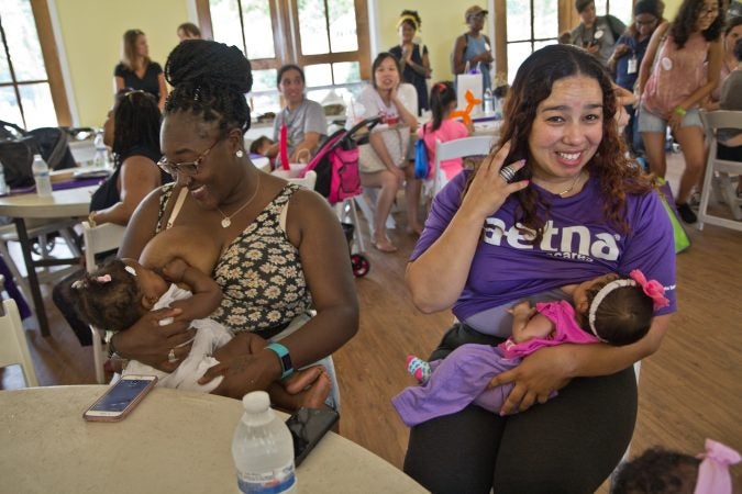 Leah Long breastfeeds 8-month-old Egypt (left), and Jezebel Ortiz breastfeeds 6-week-old Anjelize at the Big Latch event in Philadelphia. (Kimberly Paynter/WHYY)