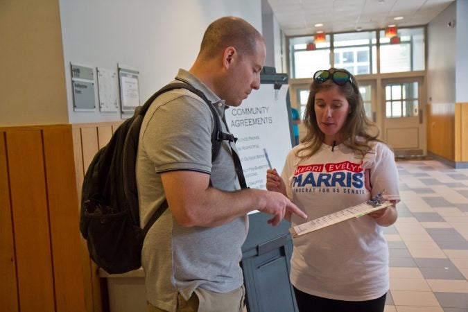 Steph Herron signs Wilmington resident Sean Vernon up to volunteer on Kerri Harris’ election campaign. (Kimberly Paynter/WHYY)