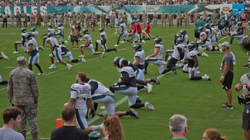 The Philadelphia Eagles strech before their first open practice Sunday evening. (Kimberly Paynter/WHYY)