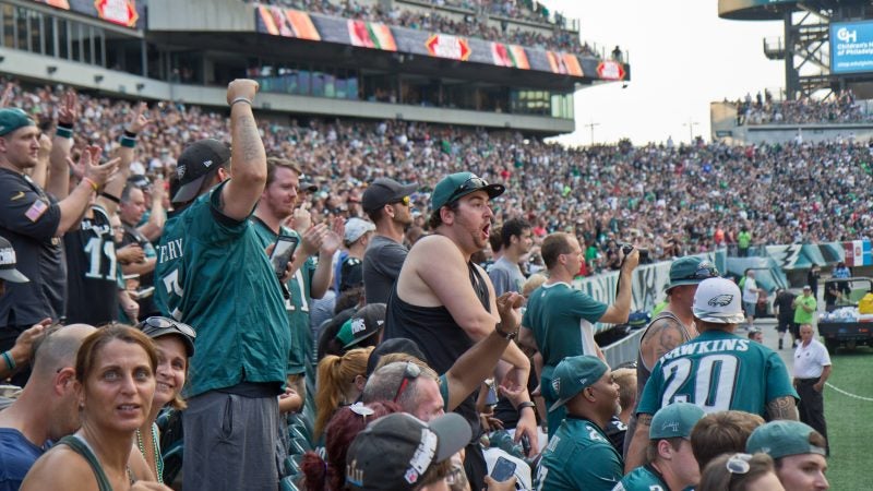 Excited Eagles fans cheer for the team at their first open practice of the season at Lincoln Financial Field Sunday evening. (Kimberly Paynter/WHYY)