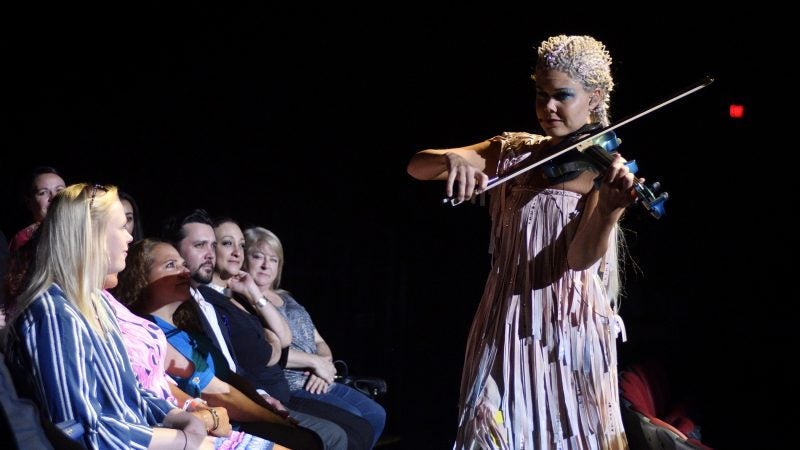 Audience members experience the performance up close as vocalist and violist Camilla Bäckman, of Finland, steps on the stage and walks through the isles during the Cirque Du Soleil’s big top show, VOLTA, in Oaks, Pa., on July 12, 2018. (Bastiaan Slabbers for WHYY)