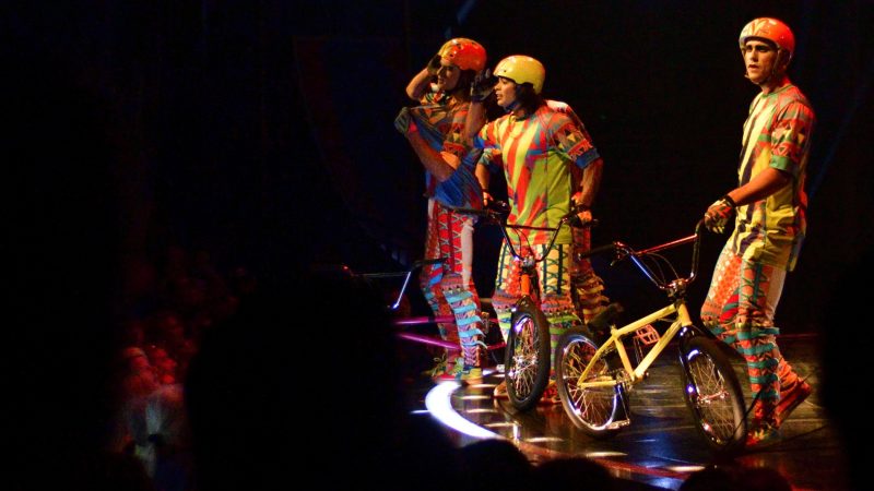 Cast members on BMX bikes interact with the audience during Cirque Du Soleil's big top show, VOLTA, in Oaks, Pa., on July 12, 2018. (Bastiaan Slabbers for WHYY)