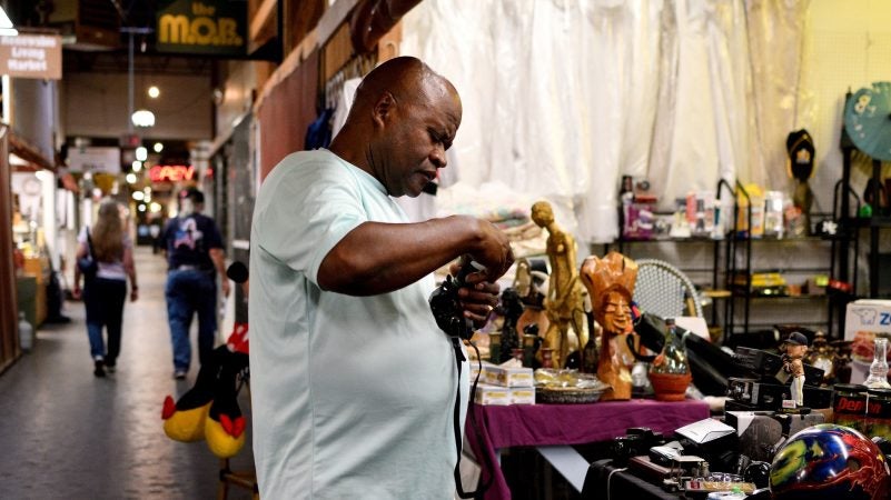 A vendor attends to his thrift shop at Zern's Farmers Market in Gilbertsville, Pa. (Bastiaan Slabbers for WHYY)