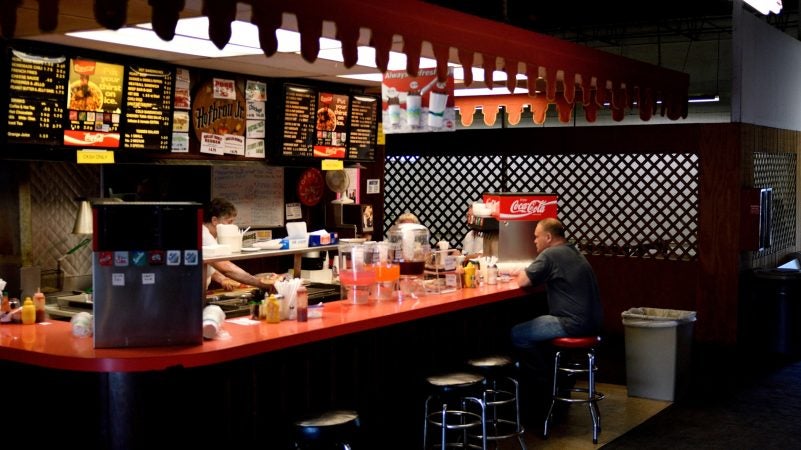 A customer sits at the counter at a tiny eatery at Zern's Farmers Market in Gilbertsville, Pa. (Bastiaan Slabbers for WHYY)