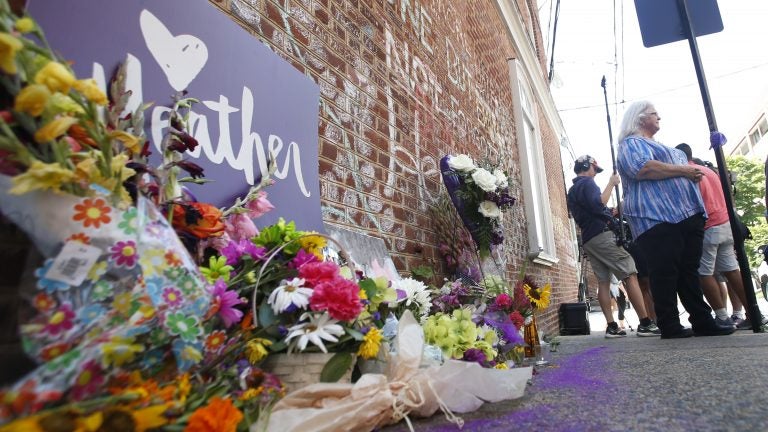 A memorial to Heather Heyer — who was killed at last year's Charlottesville rally by a driver facing murder and hate crime charges — stands at the site of her death. Heyer's mother, Susan Bro, is in the background. (Steve Helber/AP)