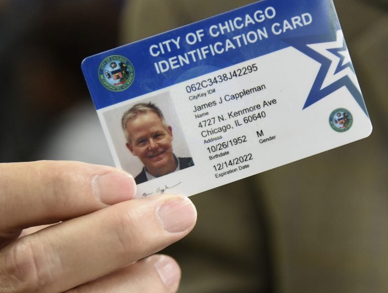Alderman James Cappleman holds his CityKey ID card, Friday, June 8, 2018, in Chicago. The city of Chicago is sending out staffers into various communities to get the municipal ID cards into the hands of undocumented immigrants, homeless people, senior citizens and others who often find it hard to obtain a valid form of identification. Officials hope that in a couple of years more than 100,000 Chicago residents will have the cards that can be used to register to vote and do things like check out a book from the library. (AP Photo/Annie Rice)