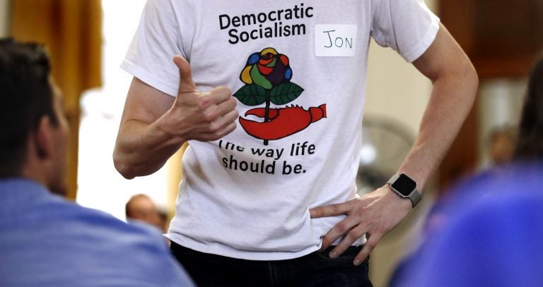 Jon Torsch, center, wears a t-shirt promoting democratic socialism during a gathering of the Southern Maine Democratic Socialists of America at City Hall in Portland, Maine, Monday, July 16, 2018. On the ground in dozens of states, there is new evidence that democratic socialism is taking hold as a significant force in Democratic politics. (AP Photo/Charles Krupa)