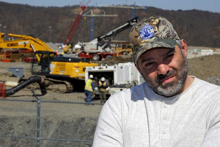 In this April 30, 2018 photo, Chip Kohser, the Beaver county Republican chairman, stands overlooking the construction of a chemical plant on the banks of the Ohio River near Beaver, Pa., that will help convert natural gas into plastic, creating hundreds of jobs in an area that has seen population dwindle since the collapse in the 1980's of the steel industry. (AP Photo/Gene J. Puskar)