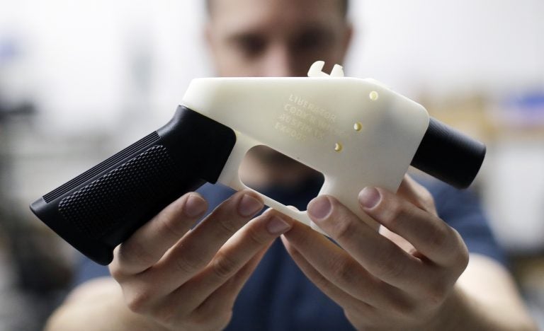 In this Aug. 1, 2018, file photo, Cody Wilson, with Defense Distributed, holds a 3D-printed gun called the Liberator at his shop in Austin, Texas. A federal judge in Seattle heard arguments Tuesday, Aug. 21, 2018, on whether to block a settlement the U.S. State Department reached with a company that wants to post blueprints for printing 3D weapons on the internet. (Eric Gay/AP Photo)