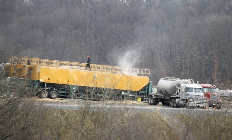 In this photo made on Saturday, Feb. 16, 2013, a worker walks on top of a container of chemicals used in the making of a brine water that is then pumped below the surface in a hydraulic fracturing process to release natural gas from shale deposits at a gas well site in Zelienople, Pa. (Keith Srakocic/AP Photo)