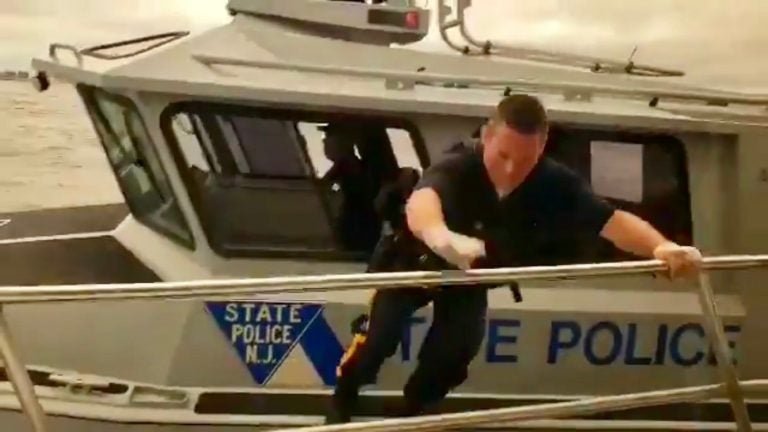 A state trooper prepares to jump onto a moving sightseeing boat off Atlantic County Monday afternoon to render assistance to an unconscious man. (Image taken from a video courtesy of Kevin Gilbert)