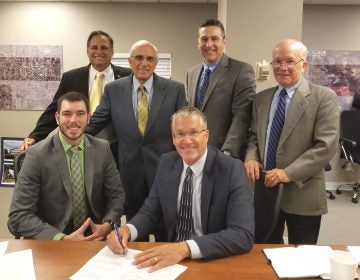 Contract signing by ACEA Executive Director Lauren H. Moore Jr. with USDA loan specialist Joseph Henry (seated to left) and (standing, from left) Max Slusher, ACEA business development director; Michael Zumpino, Triad Associates chairman and CEO; Noel McGuire, ACEA business aviation representative; and Steve Kehs, Triad Associates vice president. (Provided)