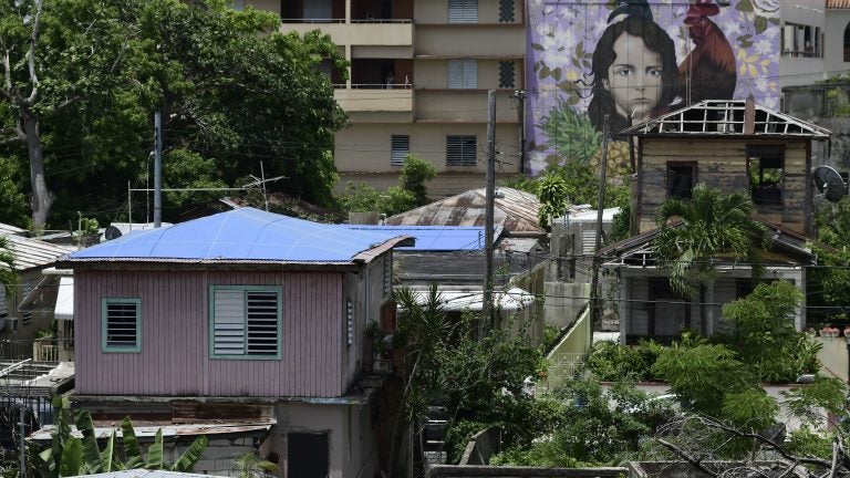 Houses affected by Hurricane Maria, some covered in tarps and missing roofs, seen in June in San Juan, Puerto Rico's El Gandul neighborhood. (Carlos Giusti/AP)