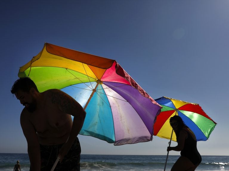 Mario Ramos (left) and wife Tally adjust their umbrellas in Laguna Beach, Calif. The state was among a number of places this summer that experienced their highest temperatures on record. (Jae C. Hong/AP)