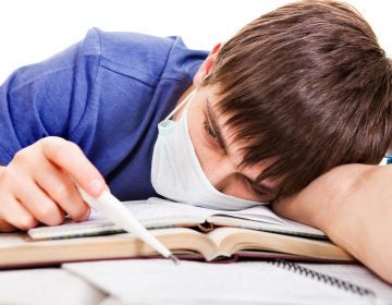 Sad and Sick Student with Thermometer and Books on the on the School Desk Sad and Sick Student with Thermometer and Books on the on the School Desk