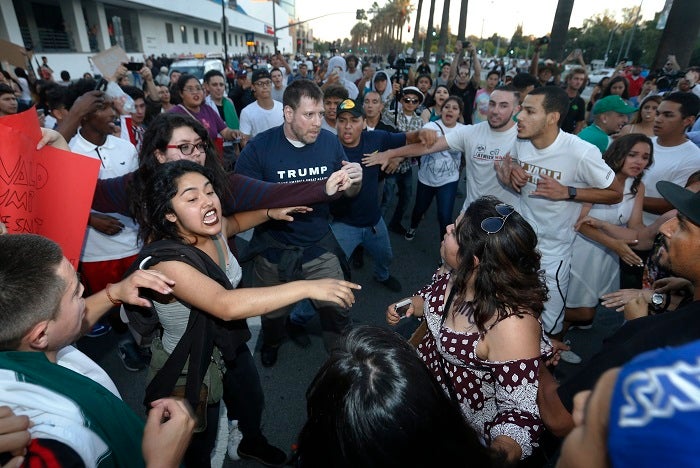 SJM-SJTRUMP-0603 Protesters surround a Trump supporter on S. Almaden Boulevard outside the San Jose Convention Center as Presidential candidate Donald Trump holds a rally in San Jose, Calif., Thursday, June 2, 2016. (Patrick Tehan/Bay Area News Group Archives)