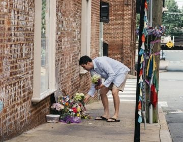 Peter Reijmers, 29, of Charlottesville, lays flowers at a memorial on 4th Street SE where Heather Heyer was killed last August. (Justin T. Gellerson/NPR)