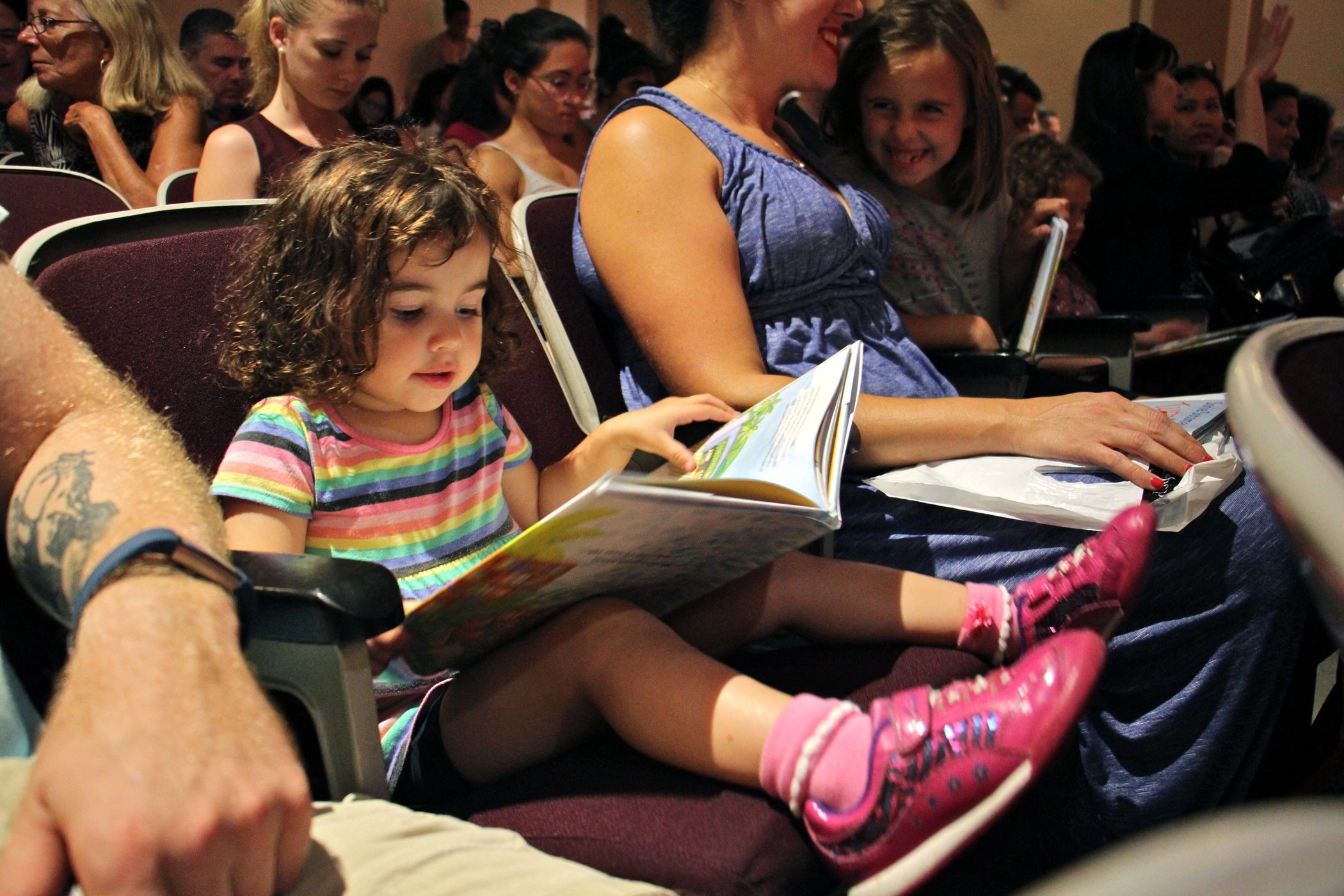 Estie Johnson, 2, of Philadelphia browses Sonia Sotomayor's new book, "Turning Pages," while waiting for the arrival of the Supreme Court Justice at the Free Public Library Central branch with her parents and two sisters. 