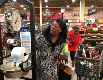 April Ellis weighs some bananas at the Island Avenue Shoprite in Southwest Philadelphia while shopping with her grandchildren,  Kalanni and Shareef. (Avi Wolfman-Arent/WHYY)