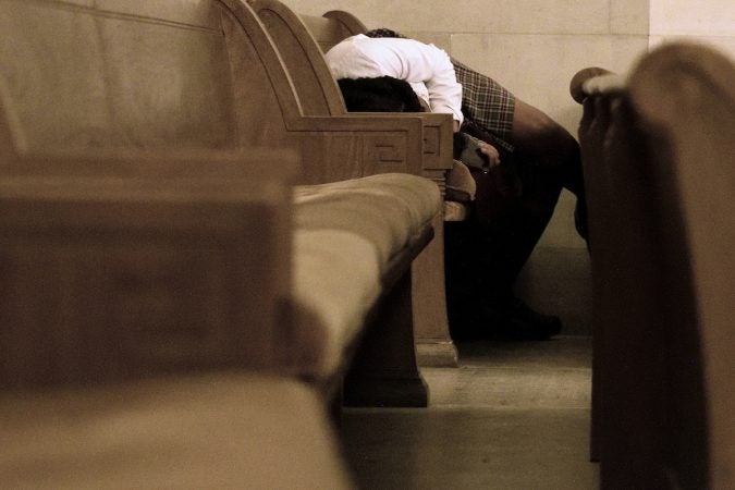 In the back of the chapel, a student finds a good place to rest in the pews. (Bastiaan Slabbers for WHYY)