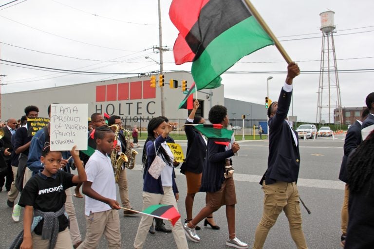 Camden students march outside Holtec International, protesting remarks made by the company's CEO Krishna Singh that residents of the city don't know how to work. The company received $260 million in tax breaks to build its manufacturing plant in Camden. (Emma Lee/WHYY)