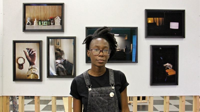 Danielle Morris stands before a collection of photographs she calls 