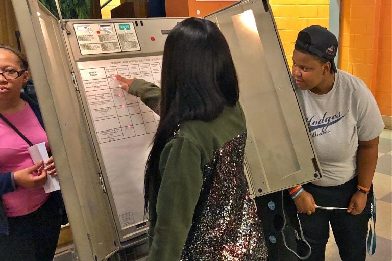 Paul Robeson High School juniors and seniors learn how to use a voting machine. Eligible students were offered a chance to register to vote during their Voter Registration Day event. (Darryl Murphy/WHYY)