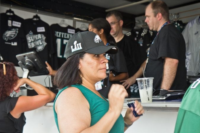 Catherine Johnson, an Eagles fan from Reno, Nevada, tries on her first Eagles hat. (Kimberly Paynter/WHYY)