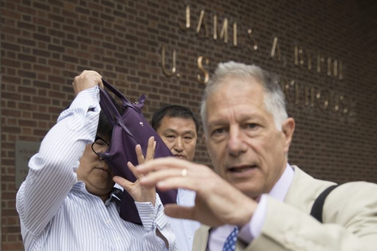 Yu Xue, left, accompanied by her attorney Peter Zeidenberg attempts to block her face with her bag as they exit the federal courthouse in Philadelphia last month. A co-conspirator, Tao Li, pleaded guilty Friday to stealing biopharmaceutical trade secrets from GlaxoSmithKline in what prosecutors said was a scheme to set up companies in China to market them. (AP Photo/Matt Rourke)