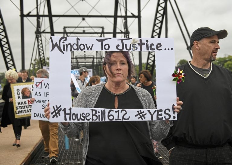 Kelly Williams carries a sign voicing support for legislation that would change the statute of limitations for child sex crimes, during a march in Harrisburg, Pa., Monday, Sept. 24, 2018. At right is her husband Brent. A proposal to give victims of child sexual abuse a two-year window to sue over allegations that would otherwise be too old to pursue was overwhelmingly approved by the state House on Monday, as supporters cheered from the gallery. (Steve Mellon/Pittsburgh Post-Gazette via AP)