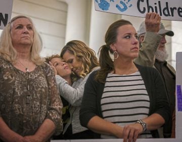 Carolyn Fortney, center, hugs her son Elias, 11, during a press conference in the state Capitol Building on Monday, Sept. 24, 2018, in support of legislation that would change the statute of limitations for child sex crimes. Carolyn is one of five sisters in the Fortney family to suffer from abuse by a priest. Others in the photograph are Judy Deaven, left, whose son Joey Behe was abused by a priest and died of an overdose in 2015; Carolyn's sister Patty Fortney-Julius, i stripped shirt, who was also abused, and the sisters' father, Edward Fortney, right. (Steve Mellon/Pittsburgh Post-Gazette via AP)