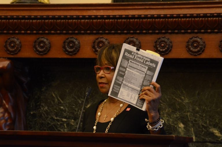 Philadelphia Councilwoman Blondell Reynolds-Brown holds up a test to check for excessive salt in food. A new city law requires restaurants to warn diners of high-sodium menu items. (Tom MacDonald/WHYY)