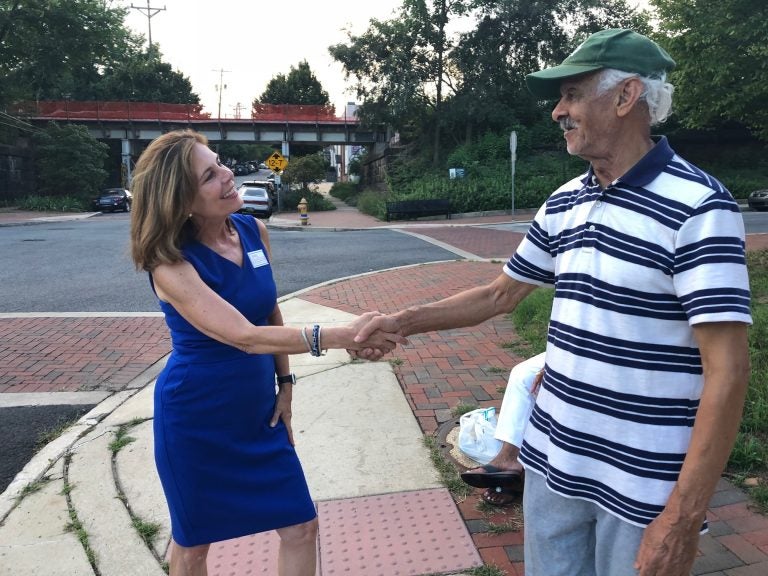 Kathy Jennings, who won Thursday's Democratic primary for attorney general, shakes hands with a voter about 6:30 p.m.  outside Lincoln Towers apartments in Wilmington's Trolley Square neighborhood. (Cris Barrish/WHYY News)