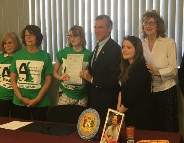 Gov. John Carney holds legislation he signed that increases funding for direct-service providers working with Delawareans with intellectual and developmental disabilities. (Mark Eichmann/WHYY)