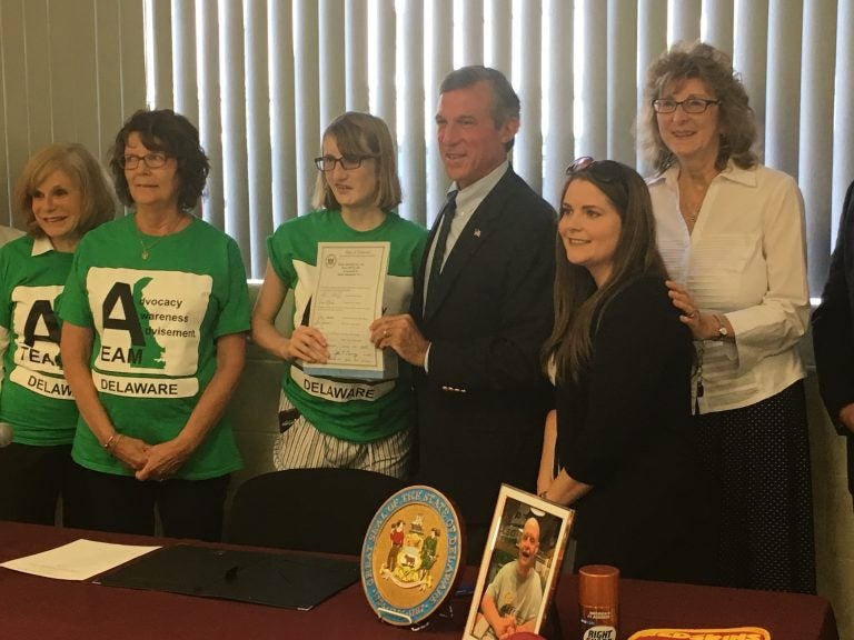 Gov. John Carney holds legislation he signed that increases funding for direct-service providers working with Delawareans with intellectual and developmental disabilities. (Mark Eichmann/WHYY)