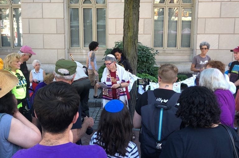 Rabbi Linda Holtzman, center, led a Tashlich ceremony in front of the U.S. Immigration and Customs Enforcement office on Chestnut Street in Philadelphia. (Darryl C. Murphy for WHYY)