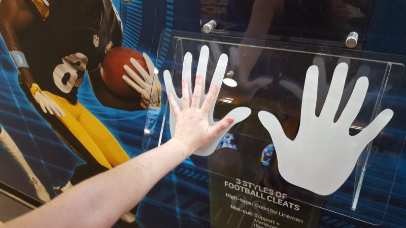 Sara Hoover compares her hand with those of  Dallas Cowboy Dak Prescott. He has the largest hands of any quarterback in the NFL.
 (Sara Hoover for WHYY)