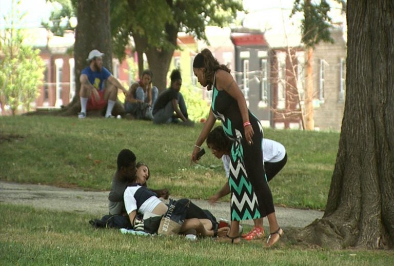 Jasmine Johnson (right), offers Narcan to people using drugs in McPherson Square Park in Kensington. The man refused her offer because he maintained the woman was breathing, and did not want to risk sending her into withdrawal. (Erika Schroeder/WHYY)