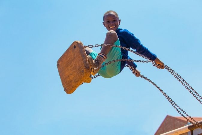 In a work by Kenyan photographer Mwarv Kirubi, a pupil from St. Martin's School Kibagare plays on the swings at break time on 27th January 2017. It is one of 98 works included in 
