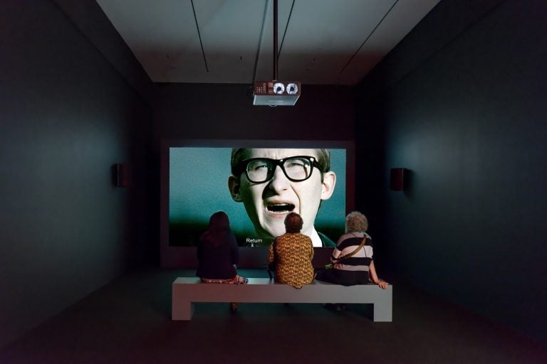 The leader of a fictional movement to repopulate Poland with Jews delivers a speech in an installation view of 