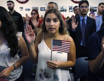 Ericka Ames, center, of Nicaragua recites the Oath of Allegiance during a naturalization ceremony at the U.S. Citizenship and Immigration Services in Miami. The backlog of citizenship applications has increased dramatically under the Trump administration. (Wilfredo Lee/AP)