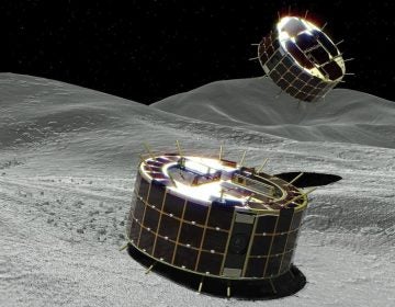 A computer graphic image provided by Japan's space agency shows two drum-shaped and solar-powered rovers on an asteroid. A Japanese unmanned spacecraft released two small rovers on the asteroid Ryugu last week.
(Jaxa/AP)