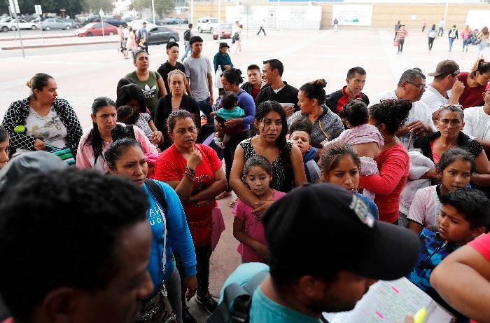 People listen as names are read off a list of who will cross into the United States to begin the process of applying for asylum Thursday, July 26, 2018, near the San Ysidro port of entry in Tijuana, Mexico. As the Trump administration faced a court-imposed deadline Thursday to reunite thousands of children and parents who were forcibly separated at the U.S.-Mexico border, asylum seekers continue to arrive to cities like Tijuana, hoping to plead their cases with U.S. authorities. (AP Photo/Gregory Bull)