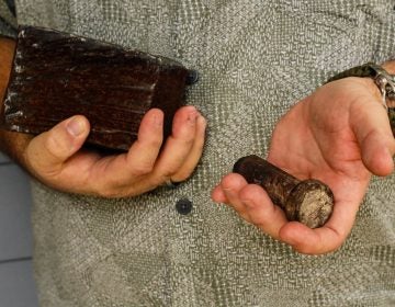 Joe Dittmar holds remnants of the World Trade Center — a section from one of the core beams of the South Tower, right, and a bolt from a steel beam. (Jud Esty-Kendall/StoryCorps)