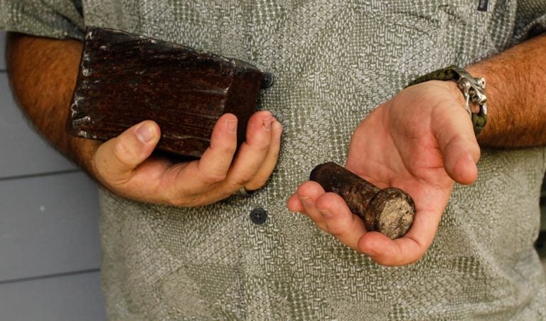 Joe Dittmar holds remnants of the World Trade Center — a section from one of the core beams of the South Tower, right, and a bolt from a steel beam. (Jud Esty-Kendall/StoryCorps)