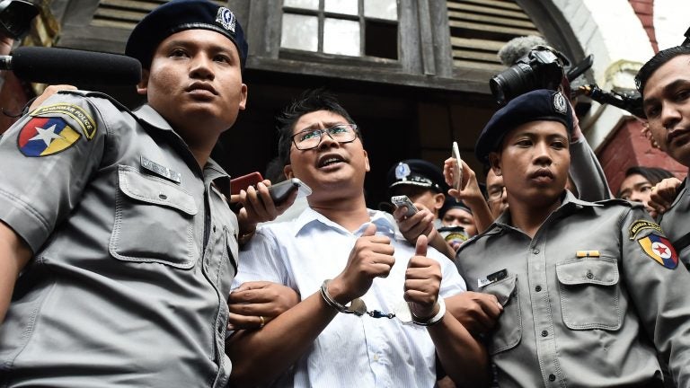Myanmar journalist Wa Lone (center) is escorted by police after being sentenced by a court to jail in Yangon on Monday. Foreign governments and human rights groups condemned the decision.